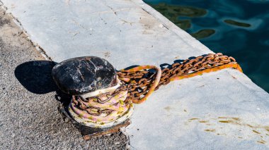 Atlantik kıyısındaki Marina'daki bir deniz yatından büyük bir dökme demir bollard yara halatında.