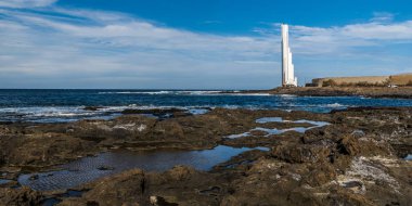 Tenerife adanın batı kıyısında büyük bir beyaz modern deniz feneri Atlantik okyanusunda gemilerin sinyalleri verir.