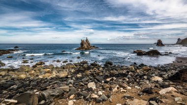 Atlantik 'in beyaz köpük dalgaları Tenerife adasının kuzey kıyısındaki küçük bir gölde kayalıklarda kırılıyor..