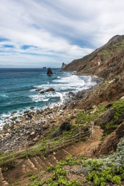 Yükselen güneşin ilk ışınları Tenerife adasının kuzey kıyısında kayalık koyları aydınlatmak.