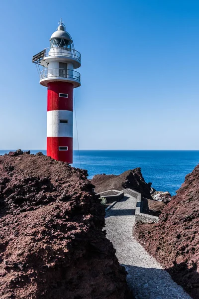Tenerife adasında kayalık bir uçurumun üzerinde eski deniz feneri.