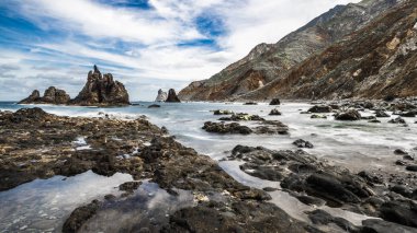 Atlantik Okyanusu 'nun öfkeli sörf Tenerife adasının kıyı kayalıkları üzerinde tatili ve küçük bir lagün aşağı yatıştırır.