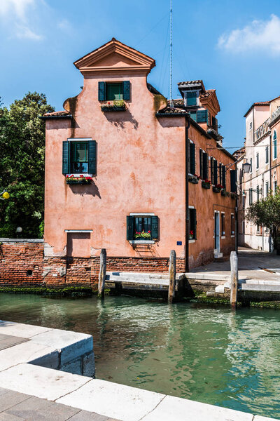 A lonely two-storey old house stands in a Park on the banks of the Venetian canal.