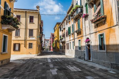 Eski Venedik'in dar sokaklarında, giysilerin halatlar üzerinde kurutulduğu alçak eski evler.