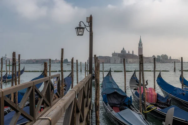 In the early morning you can enjoy a picturesque view of the Venetian gondolas at the pier on the waterfront and the island of San Giorgio Maggiore.