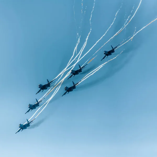 A group of military aircraft participate in demonstrations at the international air show.