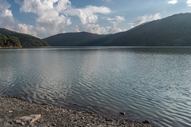 Akşam bulutları, yeşil tepelerle çevrili Abrau gölünün sakin sularına yansıyor..