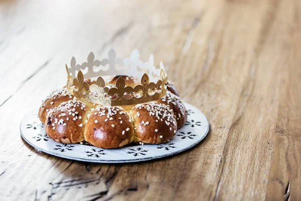 King Bread, called in German language Dreiknigskuchen, baked in Switzerland on January 6th. Small plastic miniature of the king is hidden inside of the bread. The person who finds it, is the king.