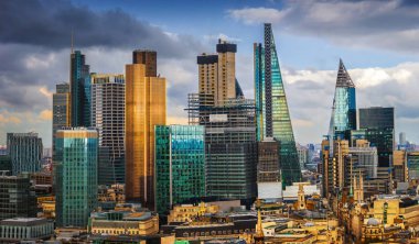 Londra, İngiltere - banka ve Canary Wharf, Londra'nın önde gelen finansal ilçeleri ile ünlü gökdelenler ve diğer yerler mavi gökyüzü ve bulutlar ile altın saat batımında panoramik manzarası görünümü