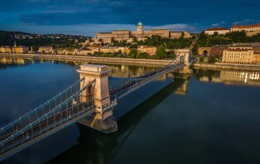 Budapest, Hungary - Aerial panoramic view of Szechenyi Chain Bridge with Buda Castle Royal Palace at background at sunrise clipart