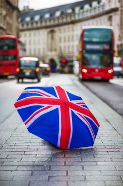 Londra, İngiltere - ikonik kırmızı çift katlı otobüs ve hareket halinde siyah taksi ile meşgul Regent Street'teki İngiliz şemsiye