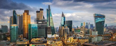 Londra, İngiltere - banka ve Canary Wharf, Londra'nın önde gelen finansal ilçeleri ile ünlü gökdelenler ve diğer yerler mavi gökyüzü ve bulutlar ile altın saat batımında panoramik manzarası görünümü