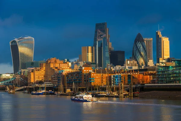 ロンドン イギリス 銀行の高層ビル 遊覧船とカラフルな暗い空と雲と黄金の時間でロンドンの主要な金融地区 — ストック写真