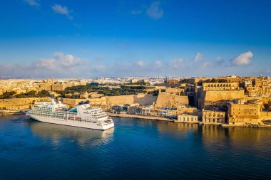 Valletta, Malta - gündoğumu Grand Harbor'da Valletta antik şehir at arka plan ile yolcu gemisi
