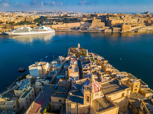 Valletta, Malta - Aerial view of Senglea, Gardjola Gardens, Saluting Battery, Upper Barrakka Gardens and Grand Harbor with Cruise ship at sunrise