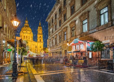 Budapeşte, Macaristan - bir Noel pazarı ve alışveriş caddesi sokak lambası, festival dekorasyon ve St.Stephen's Bazilikası arka plan'ndaki karlı gece