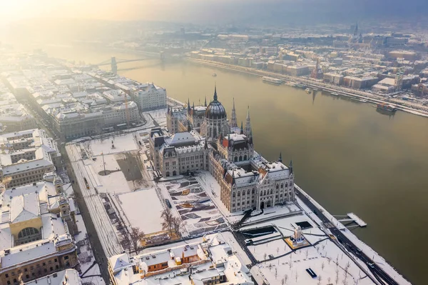 ブダペスト ハンガリー バック グラウンドでセーチェーニ鎖橋とブダ城王宮 フィッシャーマンズ バスションワーフと霧の冬の朝 ドナウ川で雪に覆われたハンガリー議会の航空写真 — ストック写真