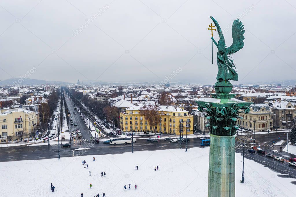 Budapest, Hungary - Aerial view of the snowy Heroes' Square with angel sculpture and Andrassy street on a winter morning