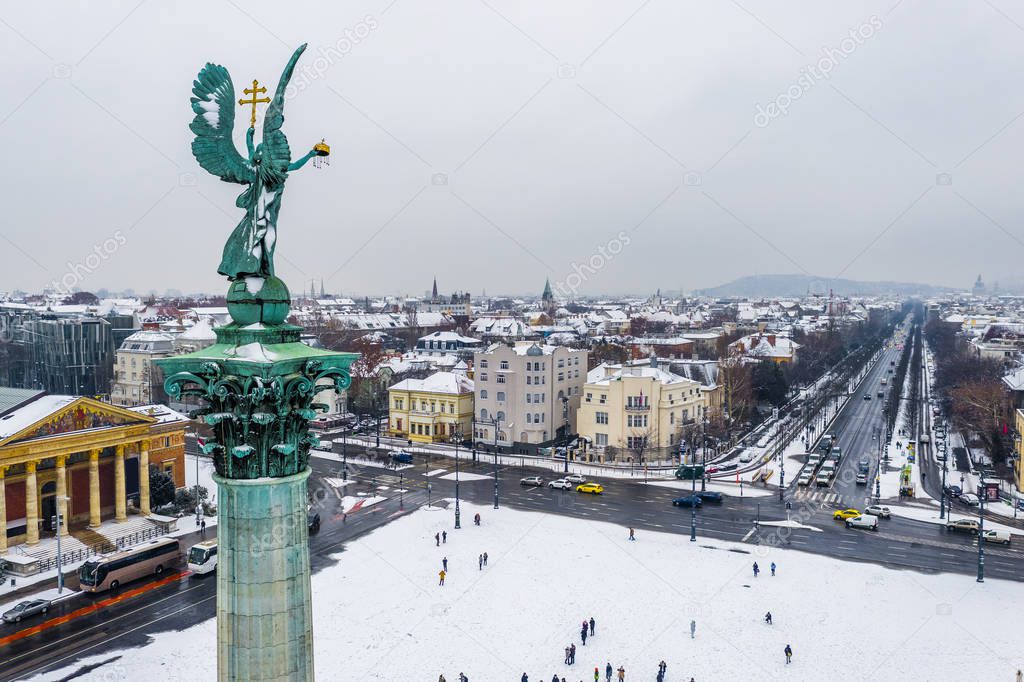 Budapest, Hungary - Aerial view of the snowy Heroes' Square with angel sculpture and Andrassy street on a winter morning