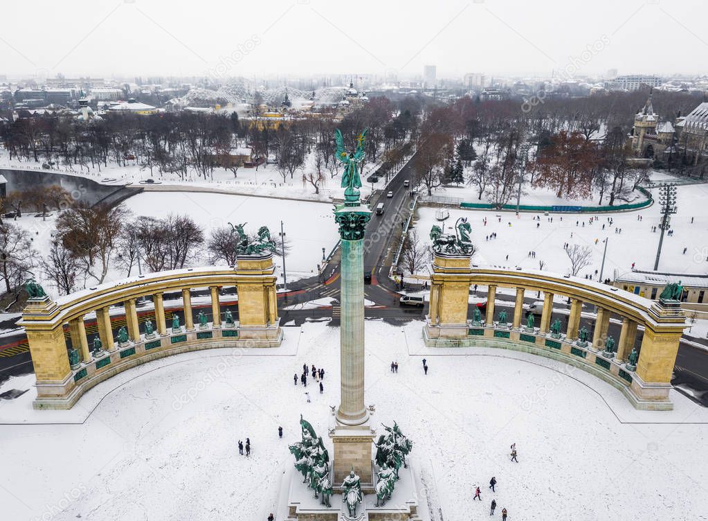 Budapest, Hungary - Snowy Heroes' Square and Millennium Monument from above on a cold winter day with City Park (Varosliget), Szechenyi Thermal Bath and ice rink at background