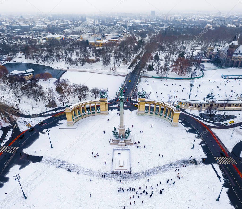 Budapest, Hungary - Snowy Heroes' Square and Millennium Monument from above on a cold winter day with City Park (Varosliget), Szechenyi Thermal Bath and ice rink at background