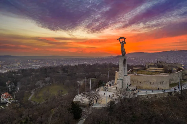 Budapest, Hongarije - Luchtfoto van het Hongaarse Vrijheidsbeeld met Buda Hills en prachtige kleurrijke zonsondergang achter in de winter — Stockfoto