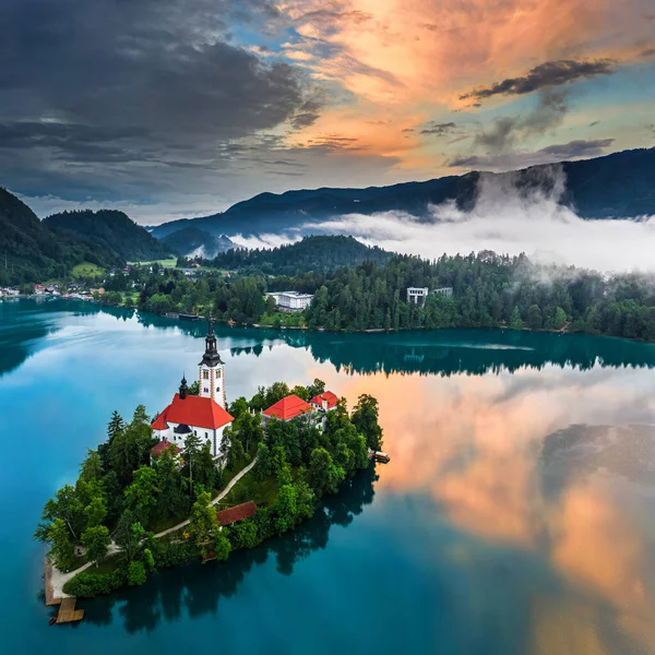 スロベニアのブレッド湖 小さな島にマリアの仮定の巡礼教会とブレッド湖 Blejsko Jezero の美しい空中ビューと夏の時間に雲と空を反映した劇的な — ストック写真