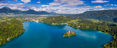 Bled, Slovenya - Bled Gölü 'nün (Blejsko Jezero) açık bir yaz gününde arka planda Maria, Bled Castle ve Julian Alps' in Hacı Kilisesi ile gökyüzü panoramik görünümü
