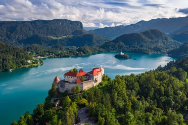 Bled, Slovenya - Bled Gölü (Blejsko Jezero) ile güzel Bled Kalesi 'nin (Blejski Grad) insansız hava aracı görüntüsü, Maria ve Julian Alps Hükmü Kilisesi parlak bir yaz gününde arka planda
