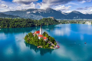 Bled, Slovenya - Güneşli bir yaz gününde Maria 'nın Hacı Kilisesi, Pletna tekneleri, Kanlı Kale ve Julian Alpleri ile Bled Gölü Havadan Görünümü (Blejsko Jezero)