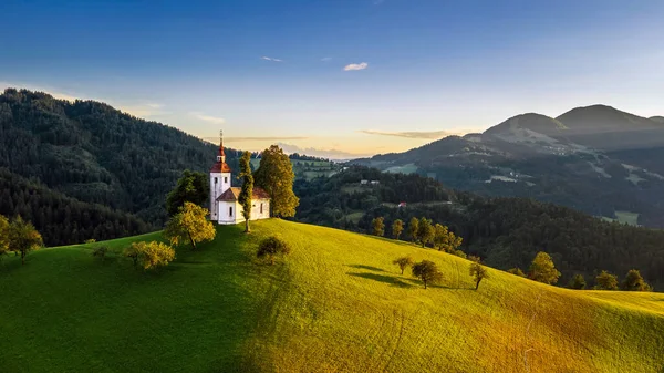 斯考法 Skofja Loka 斯洛文尼亚 空中俯瞰美丽的山顶Sveti Tomaz 圣托马斯 背景是温暖的夏日落日 晴朗的蓝天和朱利安阿尔卑斯山 — 图库照片
