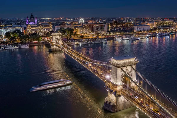 匈牙利布达佩斯 在一个阳光明媚的夏夜 在多瑙河和圣斯蒂芬斯大教堂的背景上 空中俯瞰美丽的灯光照亮的塞切尼链大桥 — 图库照片