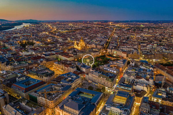Budapest, Hungary - Aerial skyline view of city centre of Budapest with Elisabeth Square, ferris wheel and St. Stephen's Basilica with clear blue and orange sky