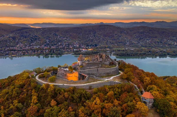 Visegrad, Macaristan - Visegrad 'da sonbahar. Renkli günbatımı ve arka planında Dunakanyar olan Visegrad 'ın güzel yüksek şatosunun insansız hava aracı görüntüsü.