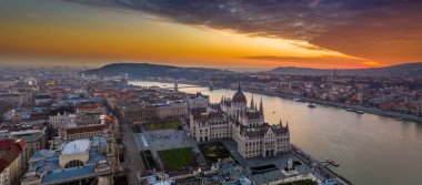 Budapeşte, Macaristan - Szechenyi Köprüsü, Buda Şatosu ile bir kış öğleden sonra Macar Parlamentosu binasının havadan panoramik manzarası ve inanılmaz renkli altın ve kırmızı gün batımı gökyüzü