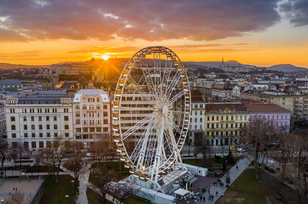 Budapest, Hungary - Aerial view of the famous ferris wheel of Budapest with Buda Castle Royal Palace and an amazing sunset at background. The wheel has been located at Elisabeth Square (Erzsebet ter)