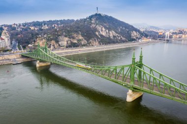 Budapeşte, Macaristan - Bir bahar sabahı, arkasında sarı tramvaylar ve Özgürlük Heykeli bulunan Özgürlük Köprüsü 'nün (Szabadsag gizli) havadan görünüşü. Coronavirus karantinasına bağlı olarak boş köprü ve yollar