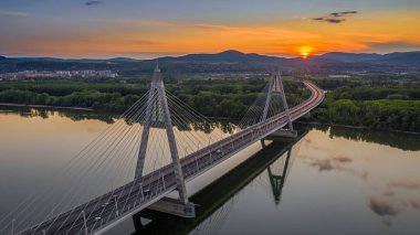Budapeşte, Macaristan - Gün batımında güzel mavi ve altın gökyüzü ve bulutlarla Megyeri asma köprüsünün havadan panoramik görüntüsü
