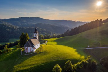 Sveti Andrej, Slovenya - Saint Andrew Kilisesi 'nin (Sv. Andrej) Skofja Loka bölgesinde gün batımında. Slovenya Alplerinde yaz zamanı