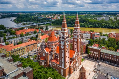Szeged, Macaristan - İç Şehir Köprüsü (Belvarosi gizli) ve mavi gökyüzü ve bulutlarla güneşli bir yaz gününde Kutsal Macaristan Kilisesi ve Katedrali (Szeged Dom) manzarası