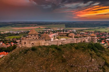Sumeg, Macaristan - Veszprem ilçesindeki ünlü Sumeg Yüksek Şatosu 'nun günbatımında fırtına bulutları ve bir yaz öğleden sonra arka planda dramatik günbatımı renkleriyle hava panoramik görüntüsü