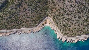Sahil şeridi boyunca uzanan temiz su ve yol manzarası.