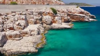 İnsansız hava aracı, açık gökyüzünün altında, altın sahil ve deniz yolunun üzerinde uçar.