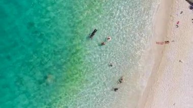 Güneşli bir Akdeniz sahilinde altın kumu olan bir kadının 4K manzarası.