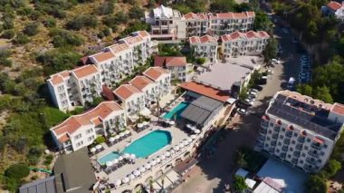 İnsansız hava aracı güneşli bir sahil ve berrak su yakınında emlak yakalıyor..