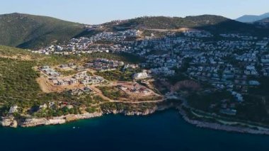 Güneş villaların, denizin ve yeşil tepelerin üzerinde yükseliyor.