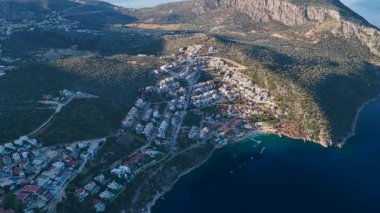 Yumuşak güneş çatılara ve deniz dalgalarına dokunur