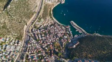 Sahil binaları, berrak deniz ve yumuşak gökyüzü.