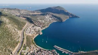 İnsansız hava aracı villaların ve parlak denizin üzerinde uçuyor.