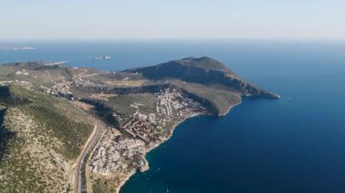 Sakin mavi suyun yakınındaki evlerin üzerinde gün doğumu